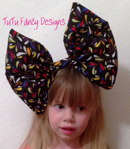 Over-sized Black Hair Bow with multicolored drops on it.